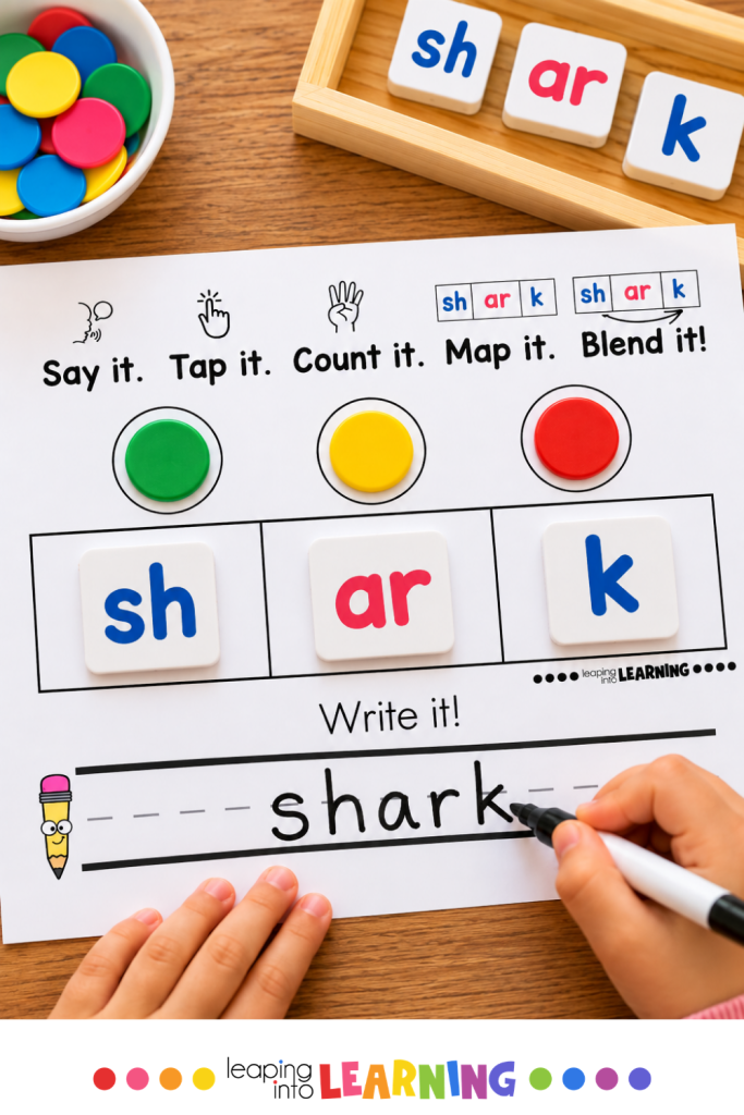 Child using a word mapping mat to map the sounds and letters in the word “shark” before writing the word.
